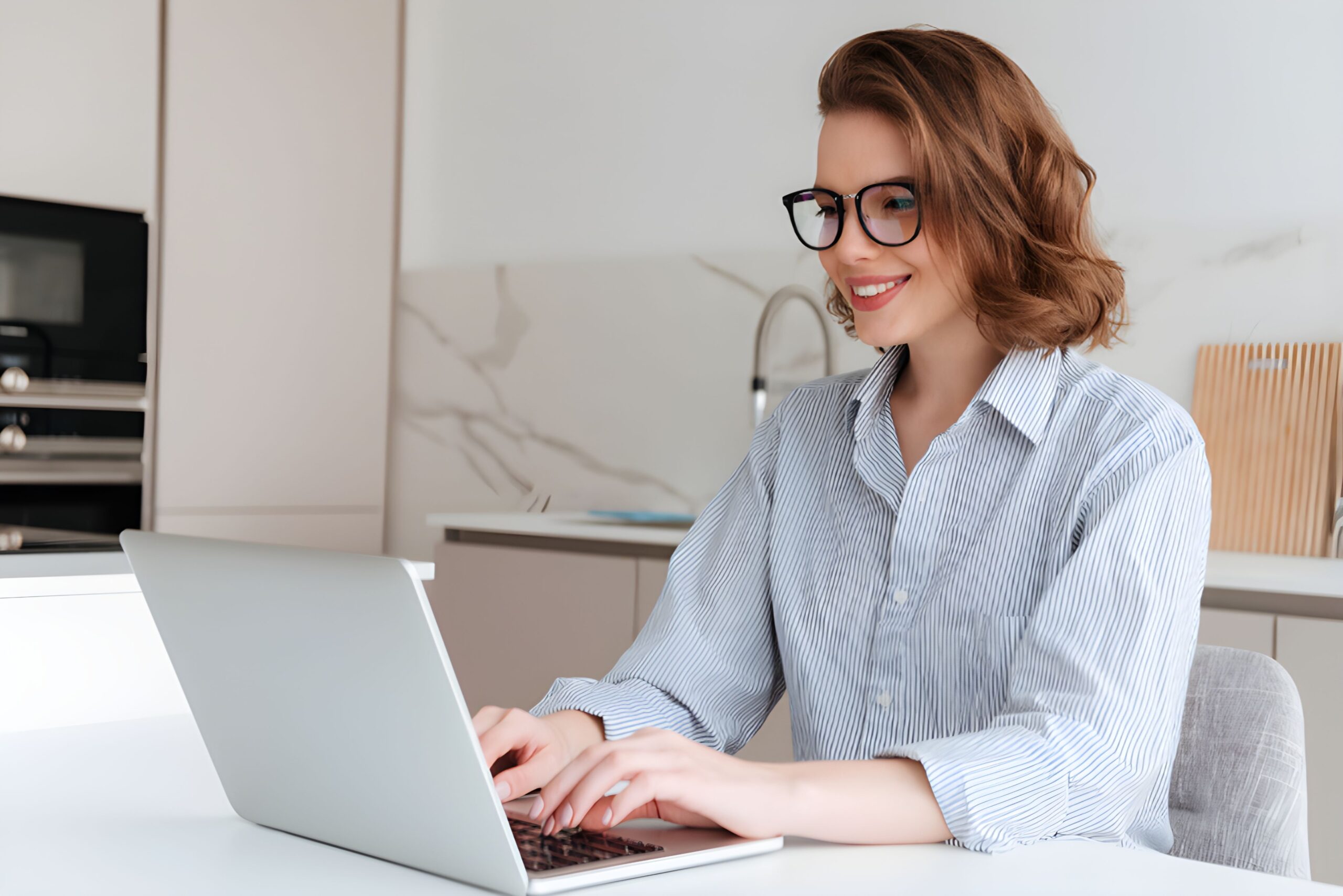 elegant-smiling-woman-glasses-striped-shirt-using-laptop-computer-while-siting-table-kitchen_1711471719657